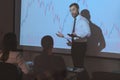 Young Businessman Explaining Graphs To His Colleagues On Projector Royalty Free Stock Photo