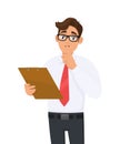 Young businessman in eye glasses holding clipboard and asking silence. Please keep quiet! Person showing or gesturing index finger Royalty Free Stock Photo