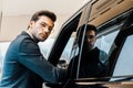 young businessman in eyeglasses posing near automobile Royalty Free Stock Photo