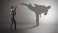 Young businessman fighting with his shadow