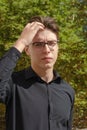 A young businessman fixes his hair with his hand. A man in a bla Royalty Free Stock Photo