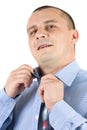 Young businessman fixing his tie isolated on white Royalty Free Stock Photo