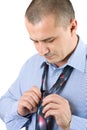 Young businessman fixing his tie isolated on white Royalty Free Stock Photo