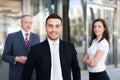 Young businessman in front of a group of business people outdoor