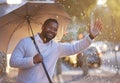 Here comes my ride, right on time. a young businessman gesturing for a cab while holding an umbrella on a rainy day in Royalty Free Stock Photo