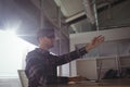 Young businessman gesturing while using virtual reality headset in office Royalty Free Stock Photo