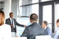 Young businessman giving presentation to colleagues in board room Royalty Free Stock Photo