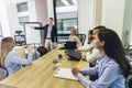 Businessman giving a presentation to his colleagues on a whiteboard in a boardroom Royalty Free Stock Photo