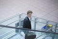 Young businessman going down a stairway with his suitcase, lookin up Royalty Free Stock Photo