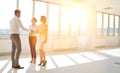 Young businessman greeting businesswoman with handshake standing by colleague in new office Royalty Free Stock Photo