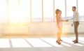 Young businessman greeting businesswoman with handshake standing by colleague in new office Royalty Free Stock Photo