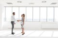 Young businessman greeting businesswoman with handshake standing by colleague in new office Royalty Free Stock Photo