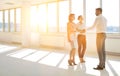 Young businessman greeting businesswoman with handshake standing by colleague in new office Royalty Free Stock Photo