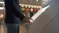 Close up shot of male hand in jacket swiping in interactive wayfinding kiosk