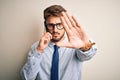 Young businessman having a conversation talking by smartphone over white background with open hand doing stop sign with serious Royalty Free Stock Photo