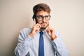 Young businessman having a conversation talking by smartphone over white background serious face thinking about question, very Royalty Free Stock Photo