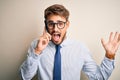 Young businessman having a conversation talking by smartphone over white background very happy and excited, winner expression Royalty Free Stock Photo