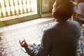 Young businessman in headphones meditating in lotus pose taking a deep breath at home.Business yoga and stress free