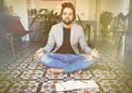 Young businessman in headphones meditating in lotus pose taking a deep breath at living room.Business yoga and stress