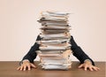 Young businessman hid behind with stack of papers