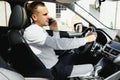 Young businessman in his car at the wheel talking on a mobile phone Royalty Free Stock Photo