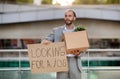 Young businessman holding cardboard sign with the text LOOKING FOR A JOB Royalty Free Stock Photo
