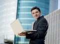 Young businessman holding computer laptop working urban business outdoors Royalty Free Stock Photo