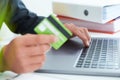 Young businessman holding a credit card and typing. On-line shopping on the internet using a laptop. Just hands over the