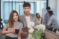 Young businessman holding digital tablet with female colleagues in background Royalty Free Stock Photo