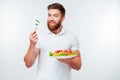 Young businessman holding fork to eat fresh vegetable salad meal