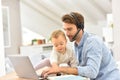 Young businessman holding his baby and working on laptop Royalty Free Stock Photo