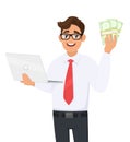 Young businessman holding laptop and showing bunch of cash, money or currency notes in hand. Stylish person using or working. Royalty Free Stock Photo