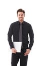 Young businessman holding laptop smiling