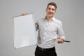 Portrait of young man with clean magnetic Board and marker in his hands isolated on white background