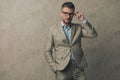 Young businessman holding one hand in pocket, fixing his eyeglasses Royalty Free Stock Photo