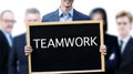 Young businessman holding sign with word Teamwork Royalty Free Stock Photo