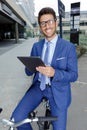 Young businessman holding tablet while on bycicle Royalty Free Stock Photo