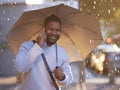 Hey, where are you now. a young businessman holding an umbrella while talking on a cellphone on a rainy day in the city. Royalty Free Stock Photo