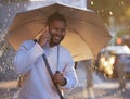 Ill meet you in a few minutes. a young businessman holding an umbrella while talking on a cellphone on a rainy day in Royalty Free Stock Photo