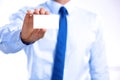 Young businessman holds out his hand with a business card