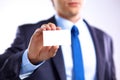 Young businessman holds out his hand with a business card