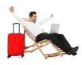 Young businessman with laptop and suitcase on sun lounger against white background. Beach Royalty Free Stock Photo