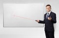 Businessman with laser pointer and copyspace white blackboard Royalty Free Stock Photo