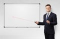 Businessman with laser pointer and copyspace white blackboard