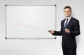 Businessman with laser pointer and copyspace white blackboard Royalty Free Stock Photo