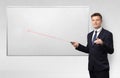 Businessman with laser pointer and copyspace white blackboard