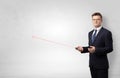 Businessman with laser pointer and copyspace white wall