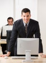 Young businessman leaning on desk