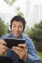 Young businessman listening to music on his MP4 player Royalty Free Stock Photo