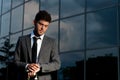 Young businessman looking clock at night Royalty Free Stock Photo